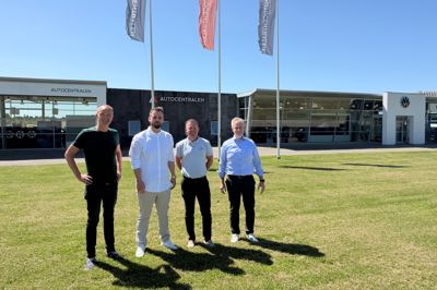 Repræsentanter for Autocentralen og Auto Group Nordvest samlet på plænen ved bilhuset på Katkjærvej 10. Det kan snart komme til at hedde AGN Skive, hvis Konkurrencestyrelsen godkender handlen.
