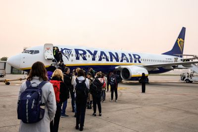 Passagerer venter på at gå om bord på et fly fra selskabet Ryanair, der ændrer praksis for familiesæder.