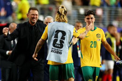 Landstræner Tony Popovic smiler, efter at Australien har sikret sig en plads i 1/16-delsfinalerne ved VM i fodbold.
