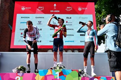 Kristian Egholm (i.m.) tager en fortjent slurk champagne efter triumfen i Herning. Mikkel Bjerg (t.v) var 0,4 sekunder efter, mens Peter Øxbenberg på tredjepladsen fra fem sekunder fra guldet.