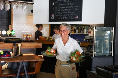 Den uge, studenterne springer ud, er en af årets travleste hos Café Garibaldi på Torvet. Når der så samtidig er DM-uge er der virkelig noget at se til. Her er Lene Dyrby på vej ud med tre stjerneskud i en rasende fart - men der er alligevel tid til et smil.