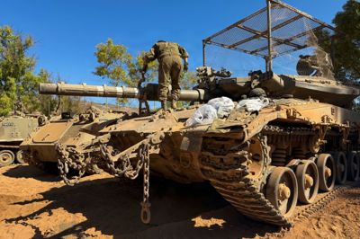 En israelsk soldat står på en kampvogn ved grænsen mellem Israel og Libanon. Kampene fortsætter nord for grænsen mellem israelske soldater og Hizbollah.