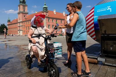 En ældre kvinde får hjælp til at fylde sin vandflaske fra en tankvogn, der uddeler gratis drikkevand i Polens hovedstad, Warszawa, søndag. Polen er et af de lande, der søndag har målt den højeste temperatur, der nogensinde er målt.