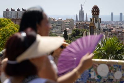En kvinde bruger en vifte til at køle sig ned i sommervarmen i den spanske storby Barcelona den 20. juni.