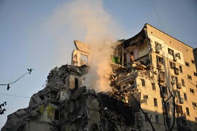 Støv og røg stiger op fra en beskadiget boligblok i den ukrainske hovedstad, Kyiv, torsdag morgen efter det, som Ukraines myndigheder kalder russiske missilangreb.