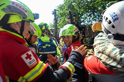 Mexicanske hjælpearbejdere fejrer torsdag redningen af den 43-årige sikkerhedsvagt Hernan Gil, der er hentet ud af murbrokkerne af en sammenstyrtet bygning. Han blev reddet, otte dage efter at to kraftige jordskælv fik hundredvis af bygninger til at styrte sammen i Venezuela.