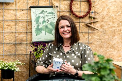Søs Philipsen er kaffe- og planteelsker. Her ses hun i det hjemmebyggede udehus i familiens skønne have.