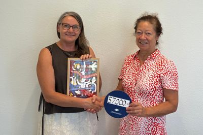 Gitte Pontoppidan (tv), der er leder af familieoplevelsesklubben, fik donationen overrakt af Eva Hancock fa LB Foreningen i Region Midtjylland sammen med et værk af kunstneren Line Jensen, nummereret og signeret af kunstneren selv.