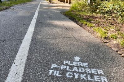 Måske kunne det have være skrevet mere tydeligt, men ny info tre steder på cykelstien ved Østre Søbad skal få flere til at bruge den nye cykel-p, der ses i baggrunden. Den er nemlig alt for ofte tom.