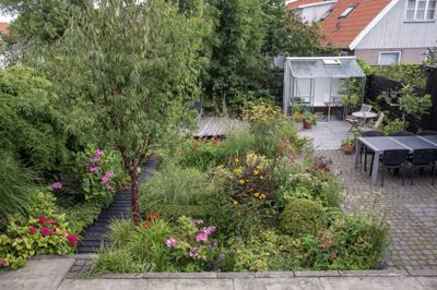 Frank Kirkegaards have er uden græsplæne, men med stor frodighed og spiselige planter mellem stauder, på vægge og i drivhus. Brugte granitsten og en lille havedam er placeret bagerst i haven med ø-terrasse.