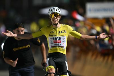 Tadej Pogacar kører jublende over målstregen på L'Alpe d'Huez.