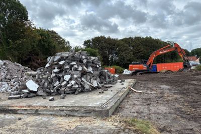 Her lå engang et hus - nu er der kun soklen tilbage. Gravemaskinen i baggrunden har lagt de genanvendelige byggematerialer i bunker.