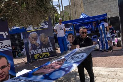 Medlemmer af Likud opsætter plakater foran et valglokale under primærvalget i Jerusalem mandag.