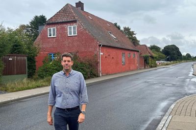 Theis W. Jeppesen, indehaver af S.E.J. Biler, ses her foran Nørre Snedes gamle stationsbygning, som bilfirmaet nu har købt til nedrivning for at skaffe mere plads til udstillingsbiler.