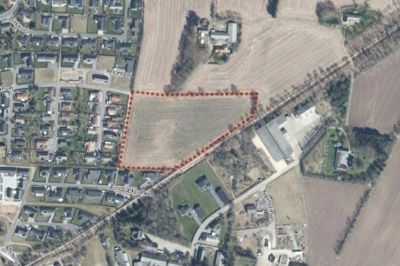 Oversigtskort over Ejstrupholm med lokalplanområdet med rød stipling. Mod vest grænser området op til boligkvarteret Ahornvej og mod sydøst ligger et erhvervsområde.