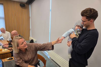 Byrådsmedlem Niels Kristian Larsen (SF) fik opmærksom forud for tirsdagens byrådsmøde. Eller retter Lauge Larsen fik opmærksomhed. Han er nemlig søn af Niels Kristian Larsen, og var med i byrådssalen forud for mødet for at hilse på faderens kolleger. Her er det byrådets sekretær Lotte Volf, der lige skal røre, smile og sige hej til Lauge