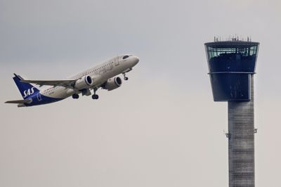 Et fly fra luftfartsselskabet SAS flyver forbi kontroltårnet i Københavns Lufthavn den 24. maj 2023.