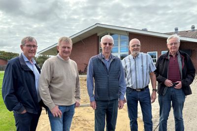 De fem formænd i Spjald Kulturhus' 25-årige historie er set fra venstre: Hans Østergaard, Flemming Meldgaard (nuværende), Bent Kærgaard, Poul Brunsgaard og Keld Jørgensen. Mellem dem og kulturhuset er anlægsarbejdet til jubilæumsstenen i fuld gang.