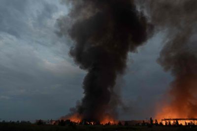 Røg stiger op over en lagerbygning, der blev ødelagt under et massivt russisk missil- og droneangreb mod udkanten af Kyiv den 5. august.