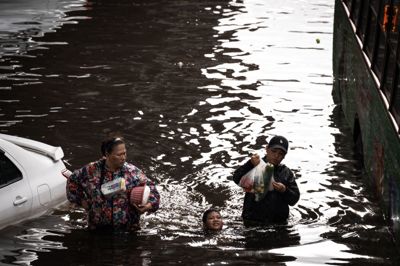 Folk går gennem oversvømmelser i Bang Kapi-nabolaget i Bangkok i Thailand den 28. september.