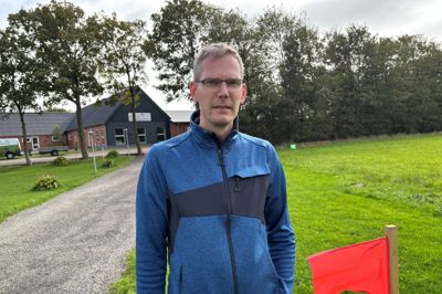 Jesper Rudmose Bach ved det røde flag, der markerer, hvor den cirka 800 meter lange grusvej skal gå fra hans ejendom ud til Brejningvej syd for Brejningrundkørslen. Han må ikke længere have indkørsel fra Rute 15, hvilket også betyder, at hans kunder skal ud på en omvej for at komme ind til hans forretning.