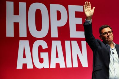 Storbritanniens premierminister, Andy Burnham, vinker til sine partifæller fra scenen ved Labour-partiets årlige kongres, der tirsdag finder sted i Liverpool.