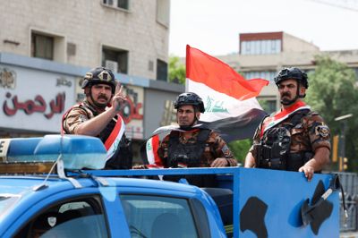 Irakiske soldater kører i konvoj i Bagdad og fejrer de amerikanske styrkers tilbagetrækning fra Irak.