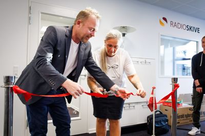 Pernille Frederiksen klipper torsdag morgen den røde snor, som Lars Bang Bertelsen holder styr på. Og dermed er det officielt, at Radio Skive nu sender fra mediehuset i Adelgade.