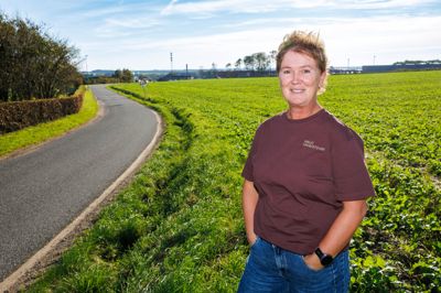 Vibeke Würtz med Skive+ i baggrunden. Biltema ønsker at bygge på marken bag hende, hvilket vil give endnu mere trafik på den smalle vej.