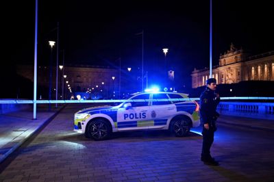 En betjent står sent tirsdag aften ved en politiafspærring, der er blevet sat op ved Det Kongelige Slot i Stockholm.