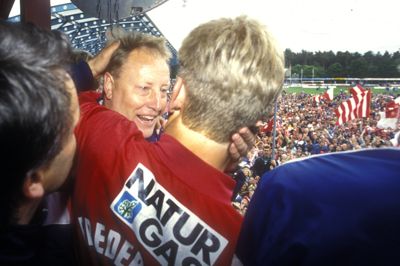 Bo Johansson omfavner angriber Søren Frederiksen på balkonen på Silkeborg Stadion, mens fansene fester på græstæppet.