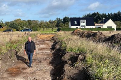 Gravemaskinerne har allerede været i gang på den nye udstykning i Gludsted. Kim Schjermer, den tidligere formand for landsbyforeningen, går her på det, der skal blive en adgangsvej.