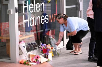 En kvinde ses tirsdag lægge blomster ved et kontor tilhørende den australske politiker Helen Haines, som natten til tirsdag lokal tid er blevet opereret, efter at hun blev påkørt af en bil i det, der menes at være et bevidst angreb.