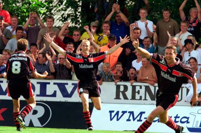 FC Midtjylland og ikke mindst angriberen Mogens Laursen (i.m.) debuterede i Superligaen med bravur i sommeren 2000. Holdets første kamp i det fine selskab var mod Lyngby, der blev besejret 4-0. Laursen, der netop var blevet hentet i Randers Freja, scorede hattrick i anden. Thomas Thomasberg (t.v.) scorede det sidste mål i kampens sidste minut. Sidste mand på billedet er Kenneth From.