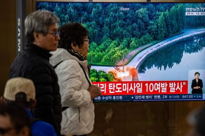 På en station i Sydkoreas hovedstad, Seoul, går indbyggere torsdag forbi en skærm, hvor en nyhedsudsendelse om den nordkoreanske missilaffyring bliver vist. Tv-billederne på skærmen er fra en tidligere affyring.
