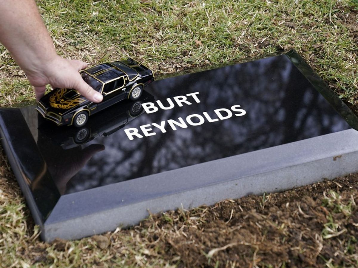 Burt Reynolds aske er begravet. En fan hylder med den ikoniske bil. Foto: Chris Pizzello/Scanpix.