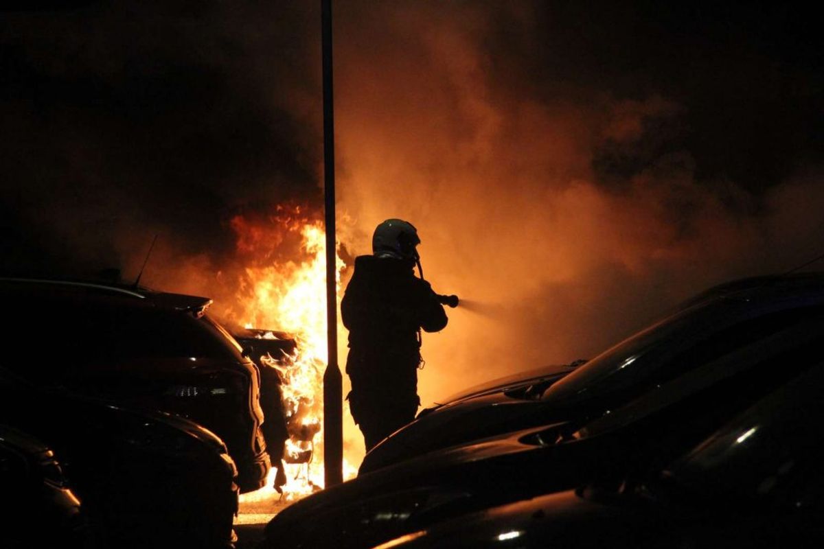 Brandmand i gang med at slukke bilbrand. Foto: Øxenholt foto/Frank Karlsen