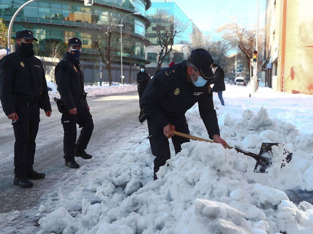 Den værste snestorm i 50 år har ramt Spanien. Her arbejde politiet i Madrid på at gøre veje og fortove farbare. Foto: Sergio Perez/Scanpix.