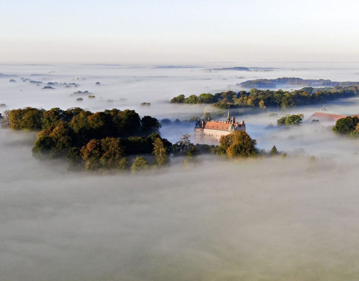 Og sådan ser herregården Egeskov (Egeskov Slot) ud, når tågen ligger som en tyk dyne. Foto: Michael Bager/Ritzau Scanpix.