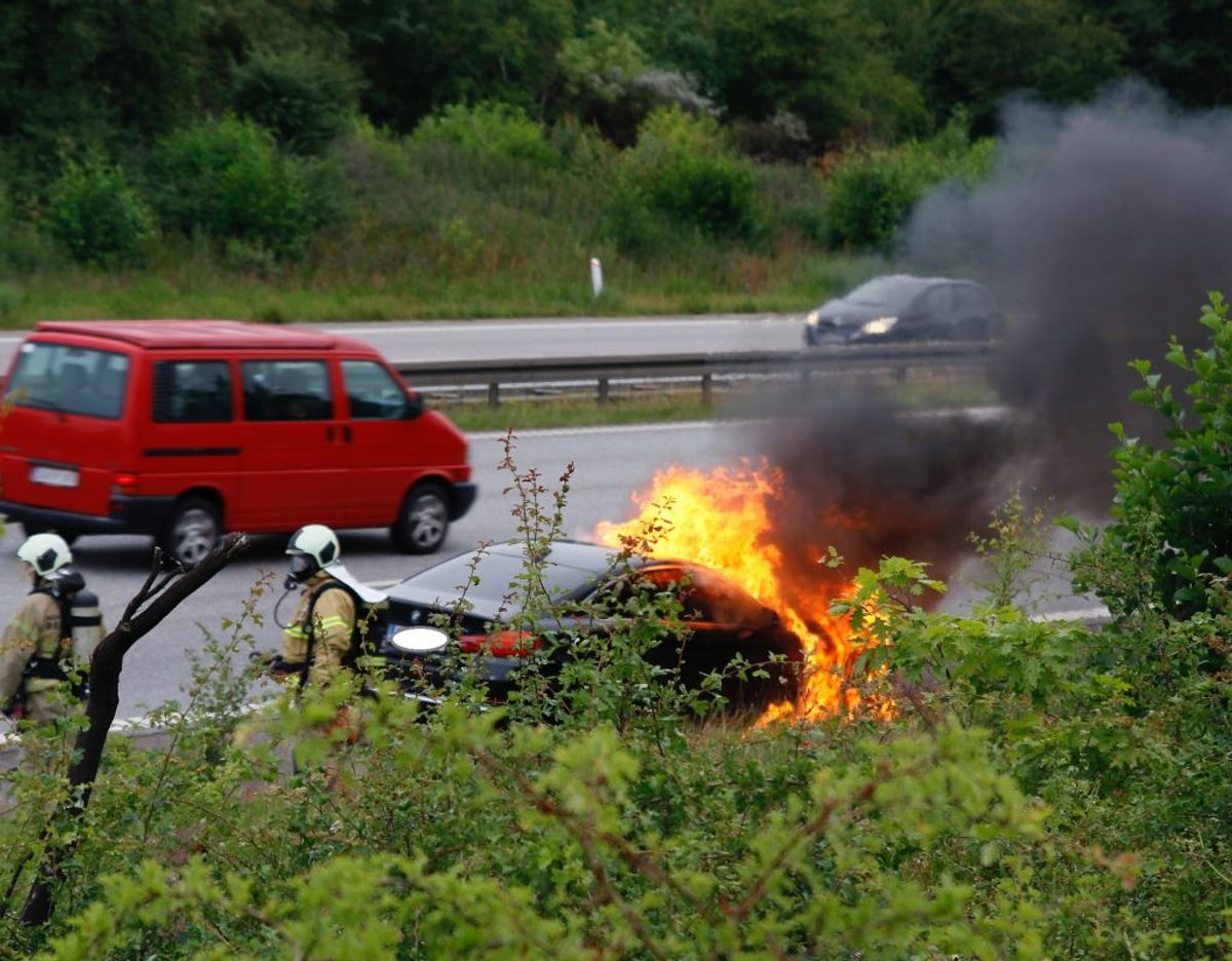 Flammerne stod op fra den store sorte BMW. KLIK VIDERE OG SE FLERE BILLEDER. Foto: Presse-fotos.dk.