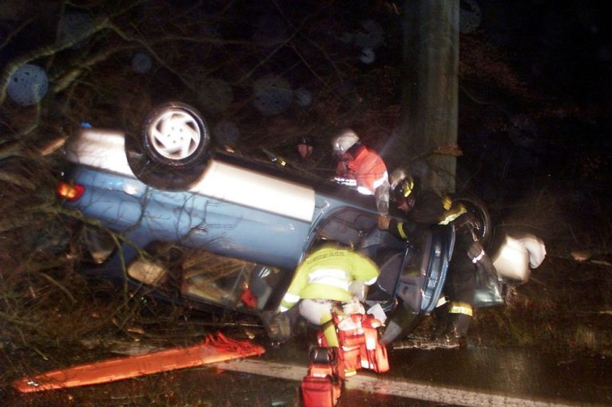 – ORKAN – Ambulancefolk holder øje med vejtrærne mens de fredag dec. 3, 1999 hjælper en bilist, som blev fastklemt, da et træ væltede hans bil. Mens ambulancefolkene forsøgte bilisten, væltede endnu et træ ned over bilen. Ambulancen måtte køre en stor omvej for overhovedet at komme frem til ham. På vej til sygehuset i Slagelse måtte de standse fire gange for at rydde vejen for træer.