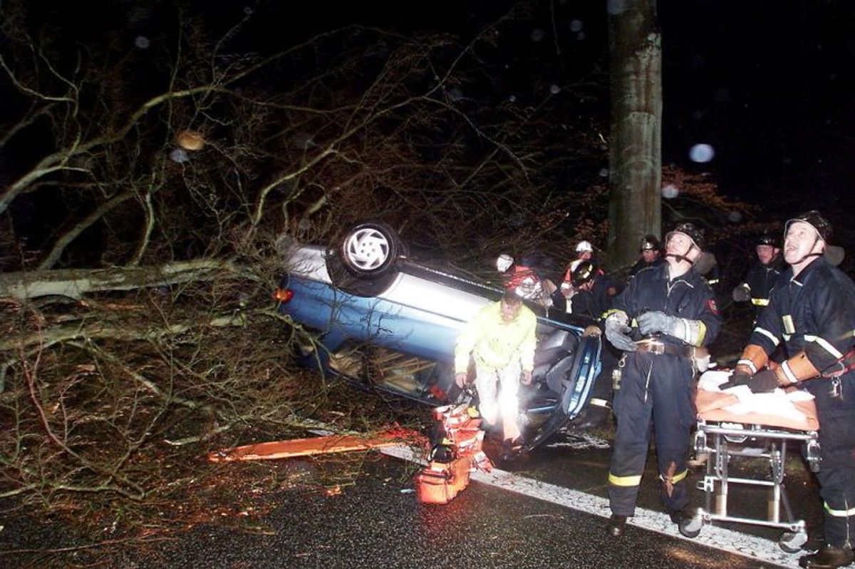 – ORKAN – Ambulancefolk holder øje med vejtrærne mens de fredag dec. 3, 1999 hjælper en bilist, som blev fastklemt, da et træ væltede hans bil.Træt til venstre faldt ned under redningsarbejdet. Ambulancen måtte køre en stor omvej for overhovedet at komme frem til ham. På vej til sygehuset i Slagelse måtte de standse fire gange for at rydde vejen for træer. Søren Steffen/NORDFOTO
