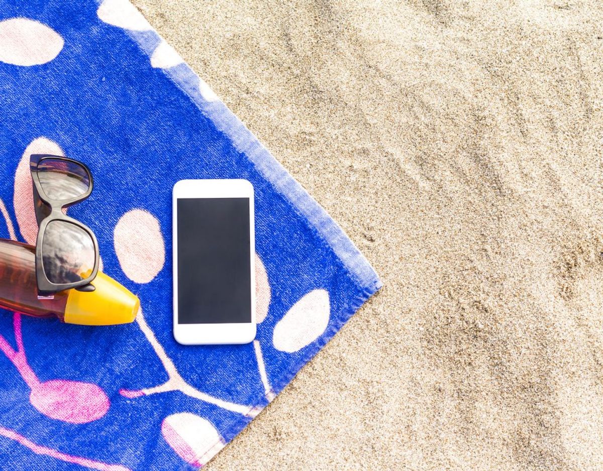 Du skal nok ikke lægge telefonen fra dig i solen. Først og fremmest kan solen overophede batteriet, der kan bryde i brand, men varmen kan også fremme kondensudvikling, så telefonen tager fugtskade. Foto: Scanpix