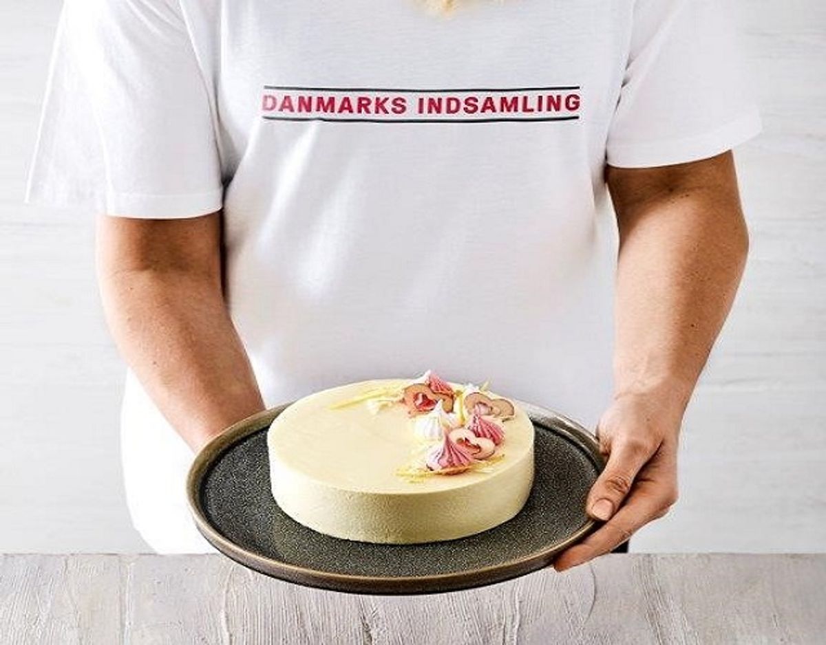 Victoria Askjær har stået for at udvikle smagen. Kagen består af en mazarinbund penslet med fin mørk chokolade, æblekompot med et tvist af citron og kardemomme, omkredset af en hvid chokolademousse lavet på den fineste hvide belgiske chokolade. På toppen er kagen pyntet med marengstoppe, den samme hvide belgiske chokolade som i moussen og strimler af citronskal. Foto: PR