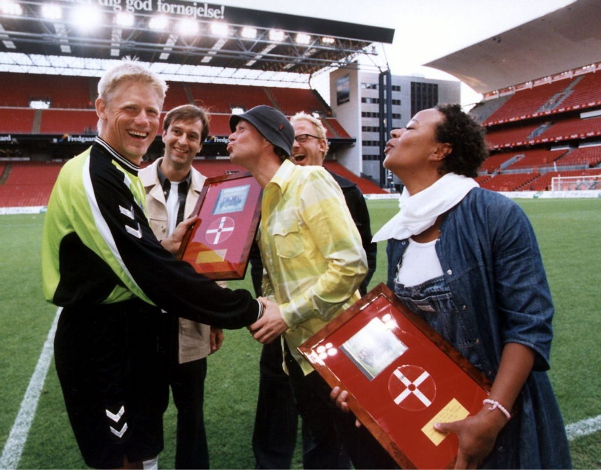 Det Brune Punktum fik en guldplade for EMsangen “All We Need is Love”. Peter Schmeichel gratulerer her Peter Frödin, Hella Joof og Martin Brygmann. Bagved står producer Nikolaj Steen. Foto: Nf/Ritzau Scanpix