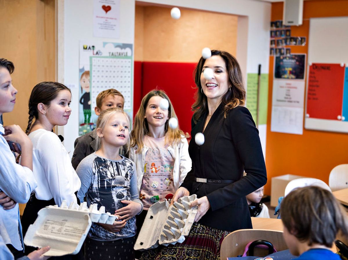 Her ses Kronprinsesse Mary til indvielsen af Nøvling Skole ved Aalborg. Under rundvisningen tog Kronprinsessen del i en læringsleg, der bestod af tennisbolde med tal i æggebakker, hvor man kastede boldene op i luften for så at samle dem igen.
Foto: Henning Bagger / Scanpix