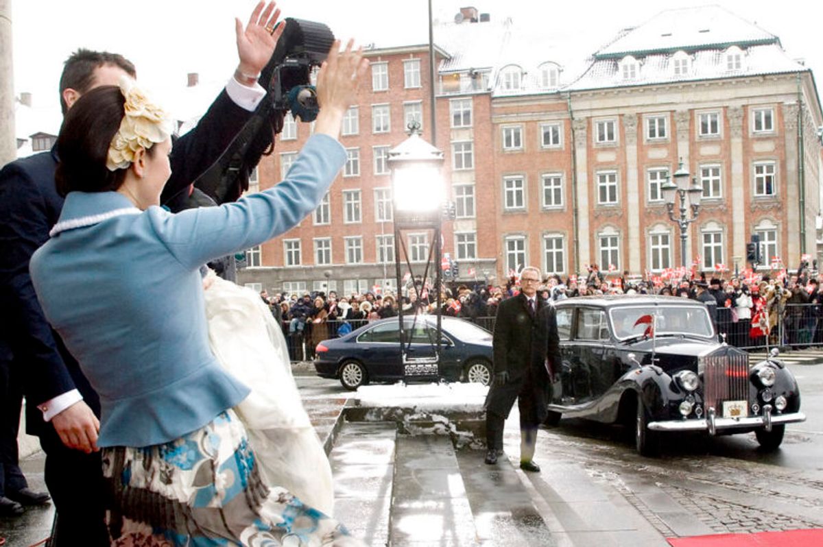 Kronprinsesse Mary med den nydøbte prins på armen og kronprins Frederik vinker til de mange frysende tilskuere udenfor Christiansborg Slotskirke lørdag d. 21. januar 2006 mens deres vogn ruller hen foran kirken Foto: Scanpix