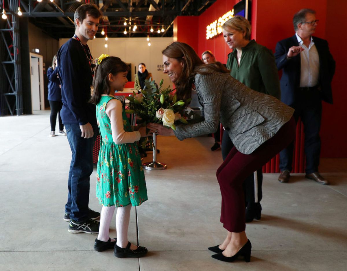 Hertuginde Kate blev hilst velkomme til arrangementet af en lille pige, der gav hende en buket blomster. Foto: Scanpix/ Yui Mok/Pool via REUTERS