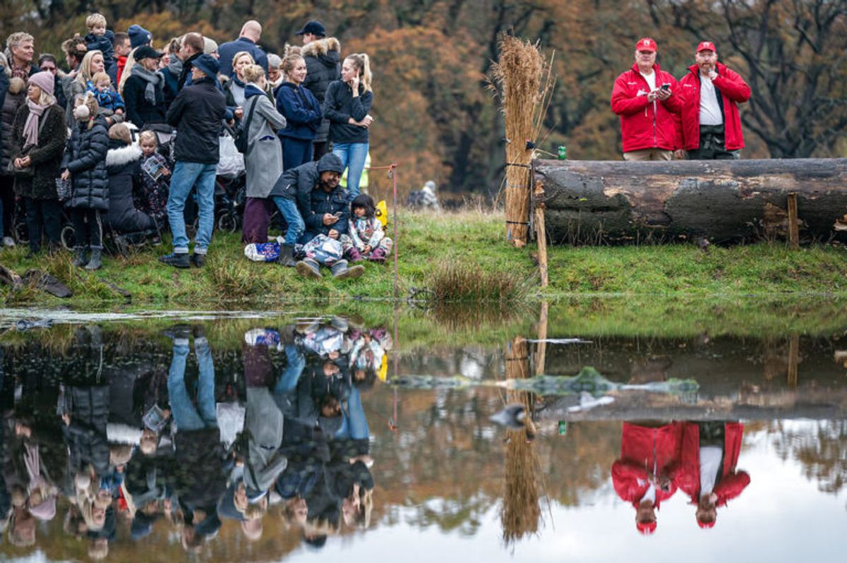 Tilskuerne venter i spænding på at rytterne skal springe i den berygtede Magasindam under Hubertusjagten 2019 i Dyrehaven ved Klampenborg, søndag den 3. november 2019. Hubertusjagten er en symbolsk videreførelse af de gamle parforce-jagter, som Dyrehaven oprindeligt er anlagt til. Her lod man hunde støve ræven op, og feltet fulgte hunde og ræv. I dag er der ingen jagthunde, og ræven er erstattet af to “forlorne” ræve i form af to erfarne ryttere, som rider forrest med rævehaler på deres røde ridejakker. Jagten er ca. 11 km lang og tager 1½ time.. (Foto: Niels Christian Vilmann/Ritzau Scanpix)