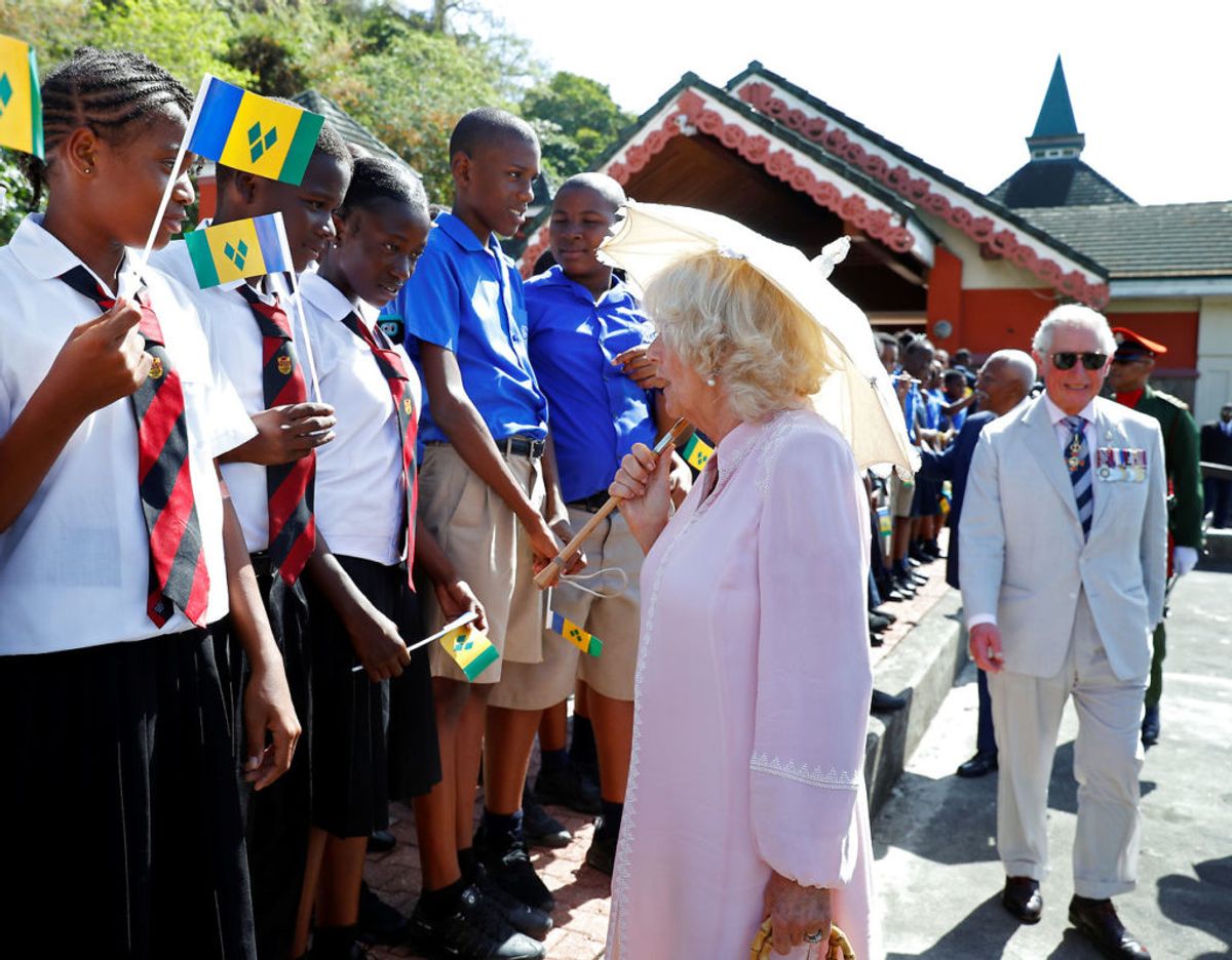 Ved ankomsten, der skete i 30 graders varme, blev Camilla, der var fikst klædt i pink, og Charles modtaget af en flok skolebørn. Foto: Scanpix/REUTERS/Phil Noble/Pool